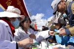 拉萨街头的“扶贫日”宣传摊位前，市民领取免费药品。新华社记者 刘东君 摄 - 中国西藏网